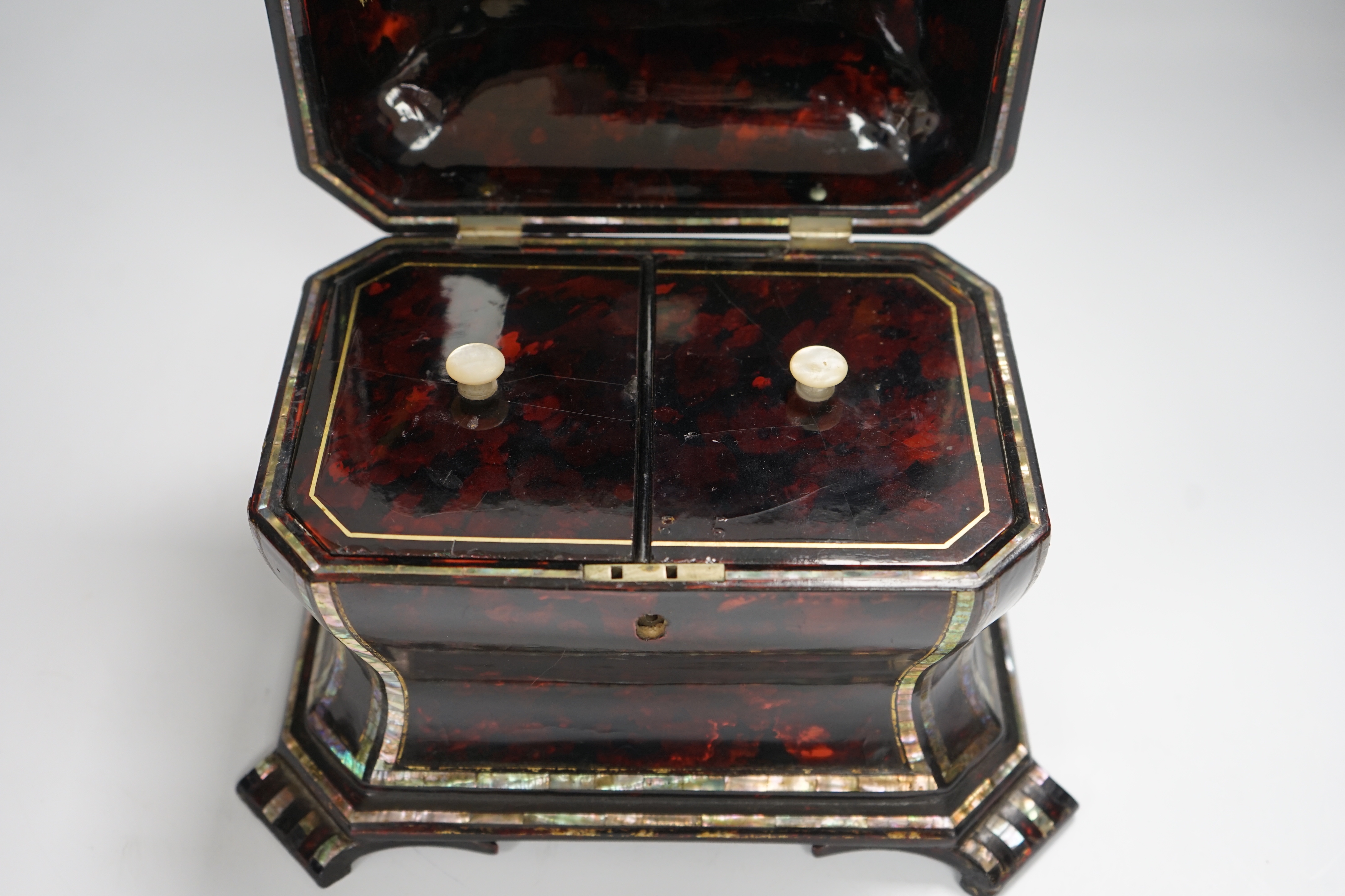 A Victorian papier mache tea caddy, stamped Jennens and Bettridge, in the form of a sarcophagus with inset mother of pearl banding, with two internal lidded compartments, 15cm high